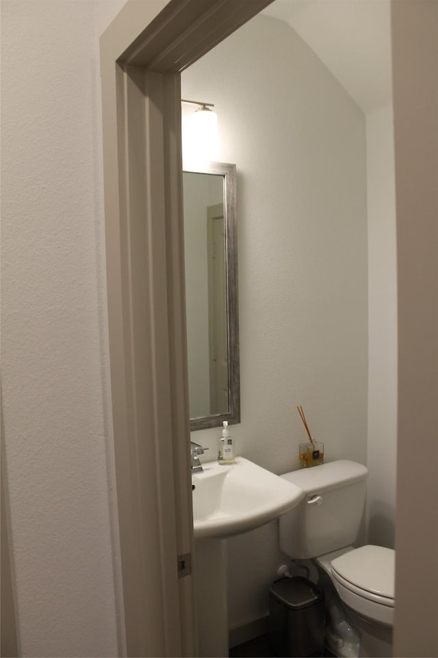 bathroom featuring lofted ceiling and toilet