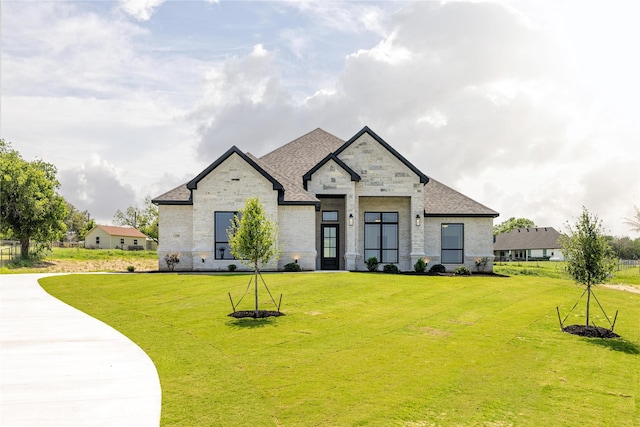 french country home featuring a front lawn