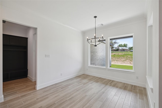 unfurnished dining area featuring crown molding, a notable chandelier, and light wood-type flooring