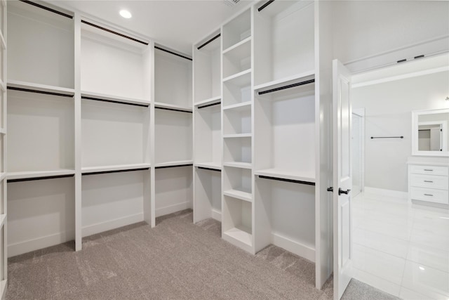 walk in closet featuring light carpet