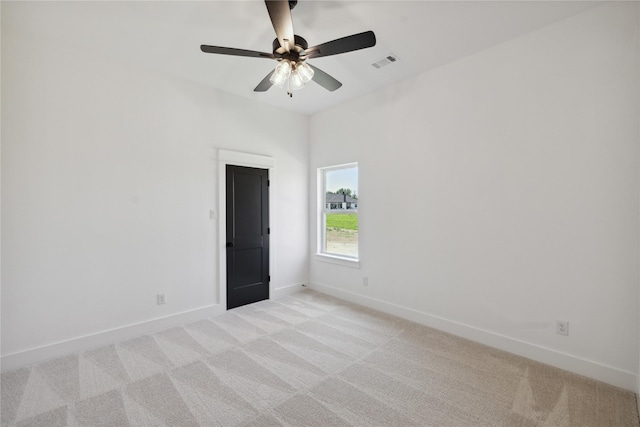 spare room with ceiling fan and light carpet