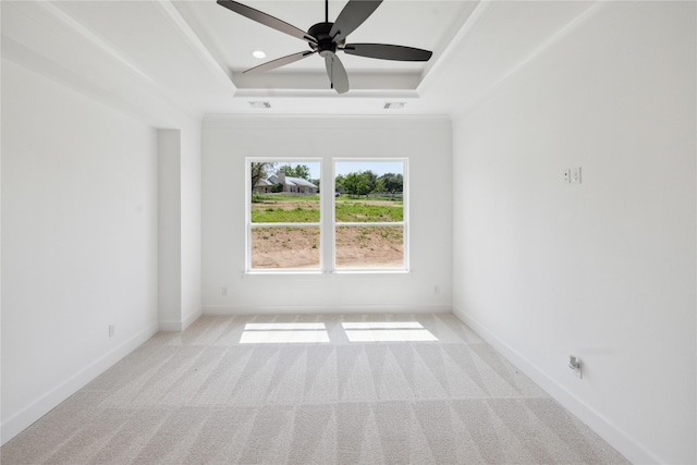 carpeted empty room featuring a raised ceiling and ceiling fan