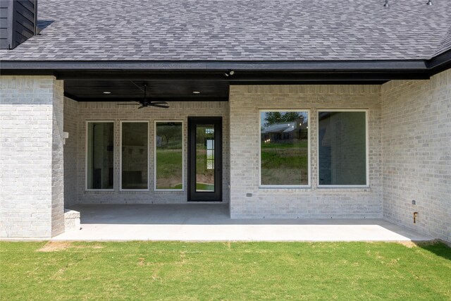 property entrance featuring a yard, ceiling fan, and a patio area