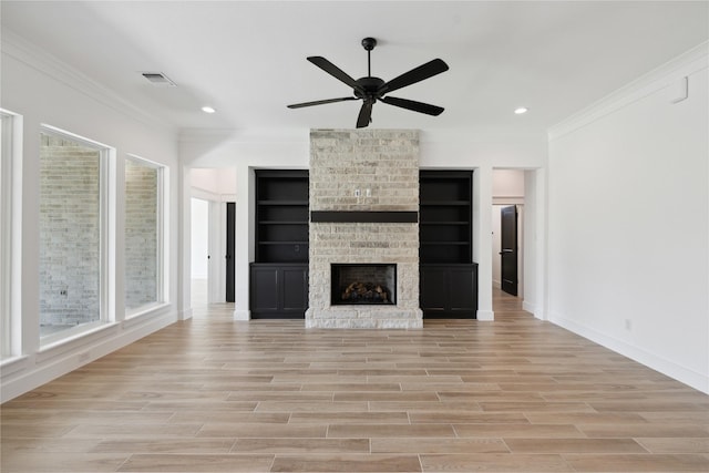 unfurnished living room featuring ornamental molding, a brick fireplace, ceiling fan, and light hardwood / wood-style flooring