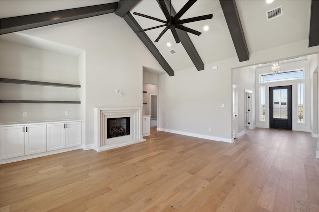 unfurnished living room featuring high vaulted ceiling, light hardwood / wood-style floors, and beamed ceiling