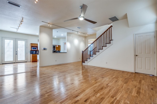 2002 Moser Ave, Dallas, TX 75206 - unfurnished living room with light hardwood / wood-style flooring, french doors, a textured ceiling, and track lighting