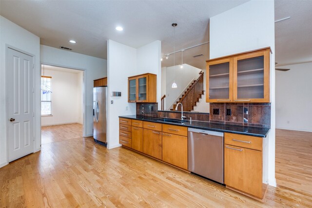 2002 Moser Ave, Dallas, TX 75206 - kitchen with tasteful backsplash, appliances with stainless steel finishes, sink, and light hardwood / wood-style floors