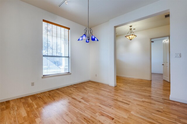 2002 Moser Ave, Dallas, TX 75206 - spare room featuring a notable chandelier and light hardwood / wood-style floors