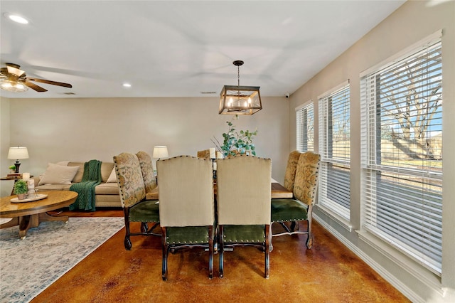 dining area featuring ceiling fan with notable chandelier