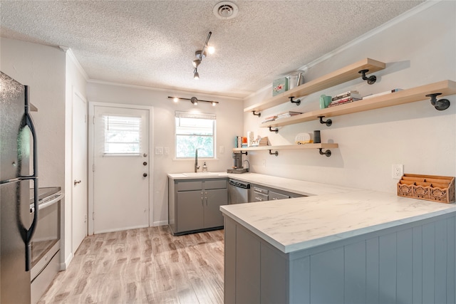 kitchen featuring sink, gray cabinetry, light wood-type flooring, appliances with stainless steel finishes, and kitchen peninsula