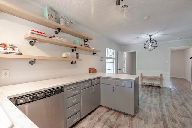 kitchen featuring gray cabinetry, light hardwood / wood-style floors, decorative light fixtures, stainless steel dishwasher, and kitchen peninsula