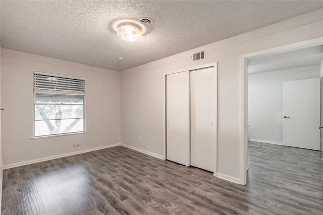 unfurnished bedroom with hardwood / wood-style flooring, a closet, and a textured ceiling