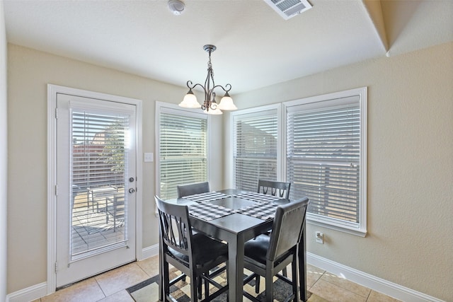 tiled dining area featuring a chandelier