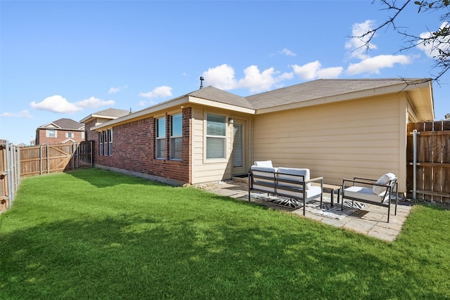 rear view of property featuring outdoor lounge area, a yard, and a patio area