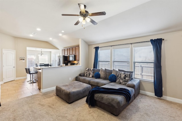 living room featuring light carpet, ceiling fan with notable chandelier, and lofted ceiling