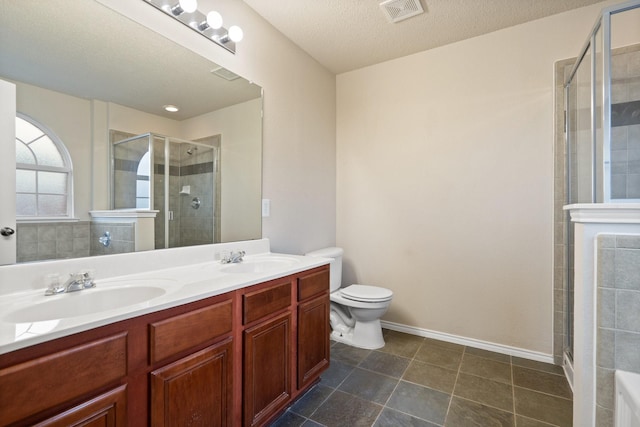 bathroom featuring vanity, a textured ceiling, a shower with shower door, and toilet