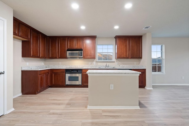 kitchen featuring a healthy amount of sunlight, appliances with stainless steel finishes, sink, and light wood-type flooring