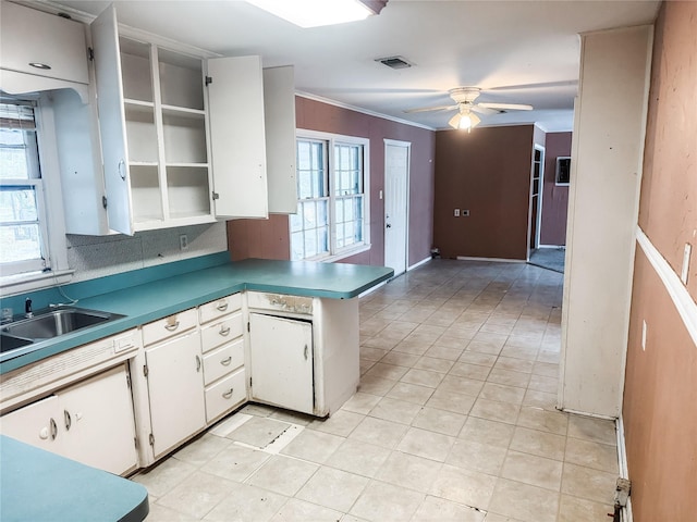 kitchen featuring crown molding, ceiling fan, tasteful backsplash, white cabinets, and kitchen peninsula