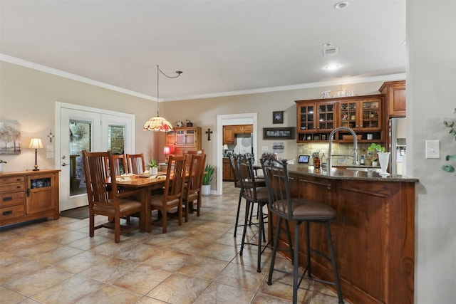 dining room featuring crown molding, sink, and french doors