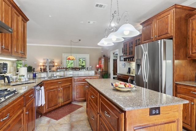 kitchen with appliances with stainless steel finishes, hanging light fixtures, backsplash, a kitchen island, and kitchen peninsula