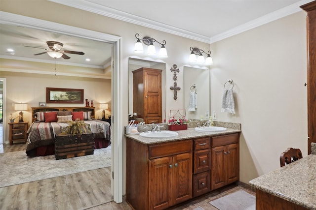 bathroom with hardwood / wood-style flooring, ornamental molding, vanity, and ceiling fan