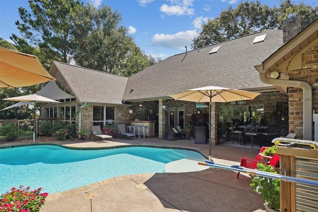 view of pool with exterior bar and a patio