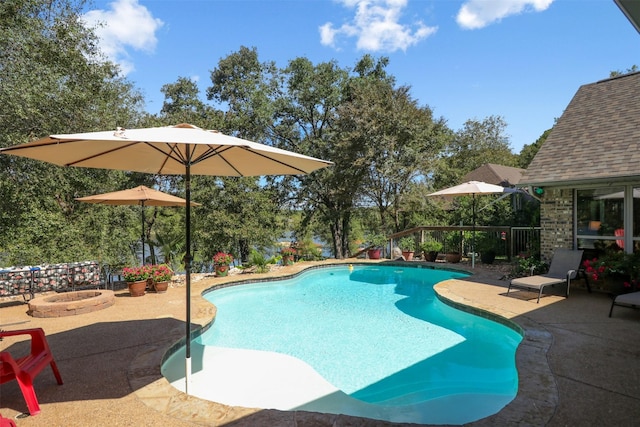 view of swimming pool featuring an outdoor fire pit and a patio