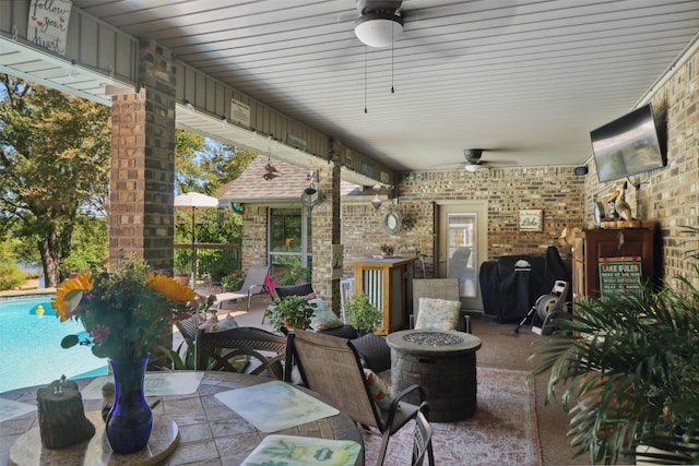 view of patio featuring ceiling fan and an outdoor fire pit