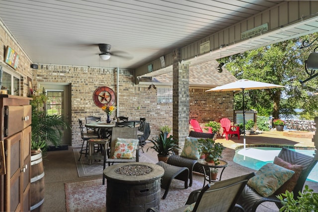 view of patio with ceiling fan and an outdoor fire pit