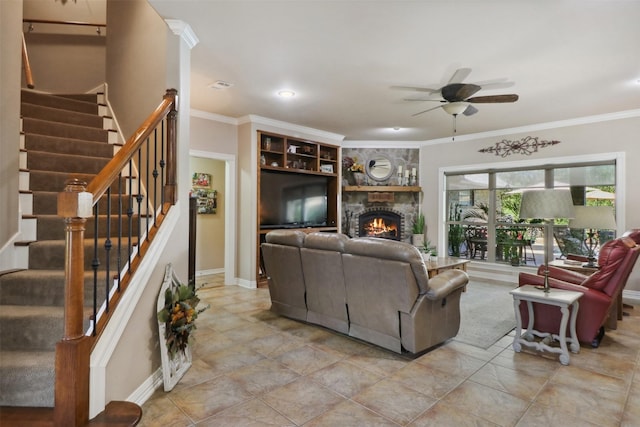 living room featuring crown molding, a stone fireplace, and ceiling fan