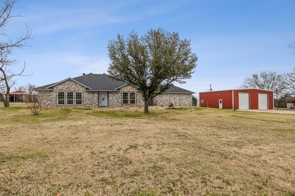 exterior space with a garage, an outdoor structure, and a front yard