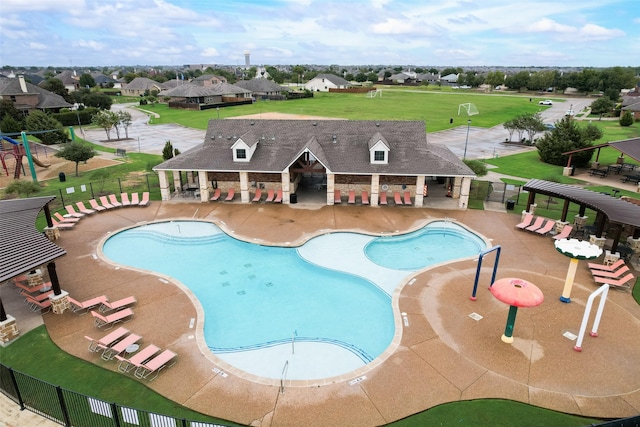 view of pool with a patio area and a lawn