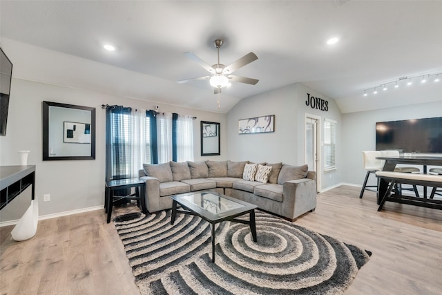 living room with ceiling fan, light hardwood / wood-style floors, and vaulted ceiling