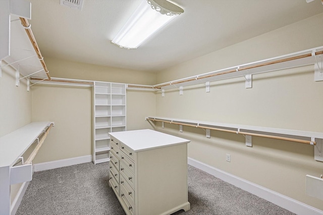 walk in closet featuring dark colored carpet