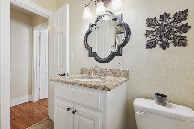 bathroom featuring vanity, hardwood / wood-style floors, and toilet