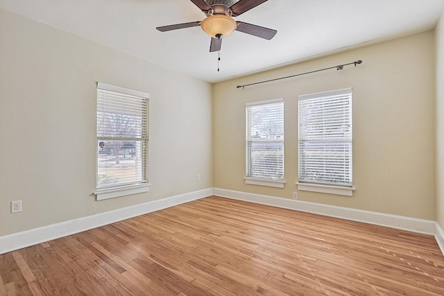 spare room with a wealth of natural light, ceiling fan, and light wood-type flooring