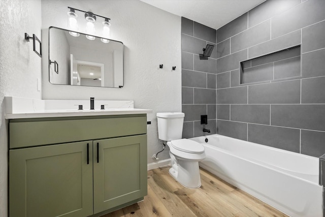 full bathroom featuring tiled shower / bath combo, wood-type flooring, vanity, and toilet