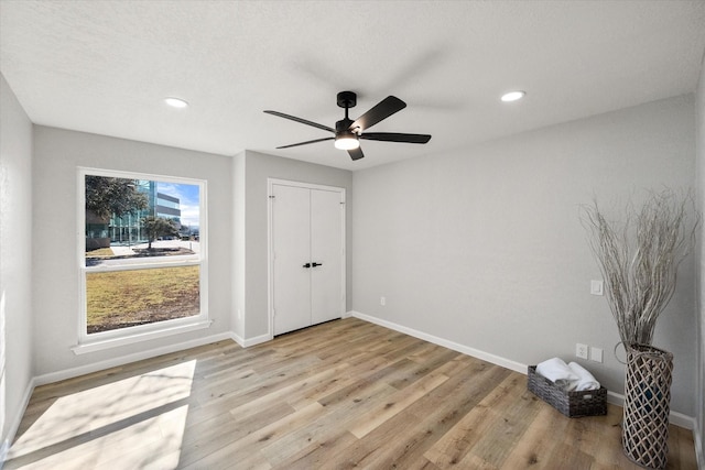 unfurnished bedroom with recessed lighting, light wood-type flooring, and baseboards