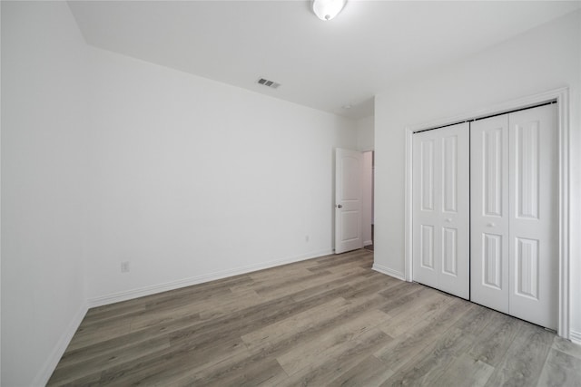 unfurnished bedroom featuring light hardwood / wood-style floors and a closet