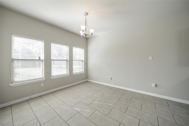 empty room featuring light tile patterned floors and an inviting chandelier