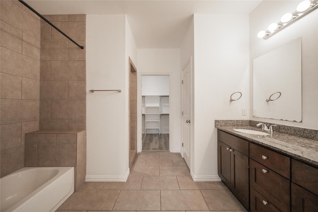 bathroom featuring tiled shower / bath, tile patterned floors, and vanity