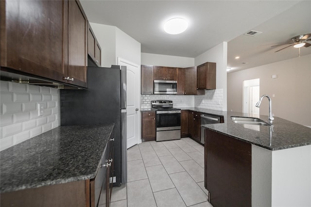 kitchen with dark brown cabinetry, sink, light tile patterned floors, appliances with stainless steel finishes, and ceiling fan