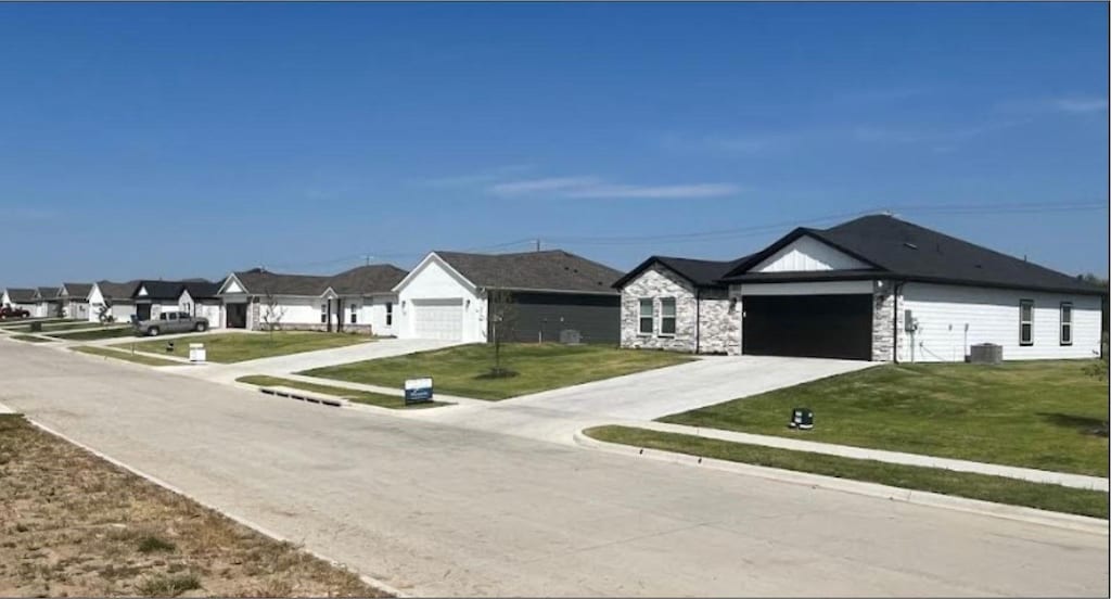 view of front of home with central AC unit and a front lawn