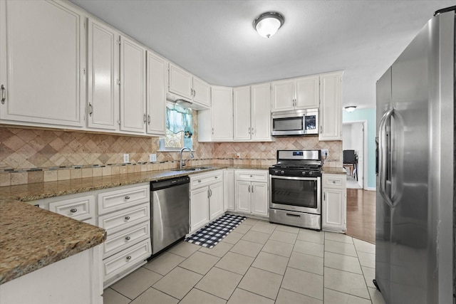 kitchen featuring white cabinetry, light stone counters, tasteful backsplash, and stainless steel appliances