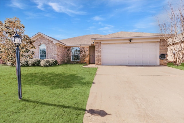 single story home with brick siding, a garage, driveway, and a front yard