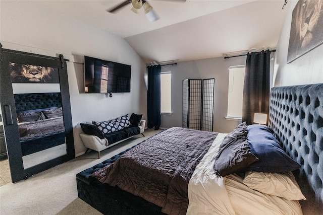 bedroom with ceiling fan, lofted ceiling, a barn door, and carpet floors