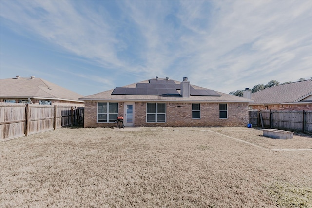 rear view of property with solar panels