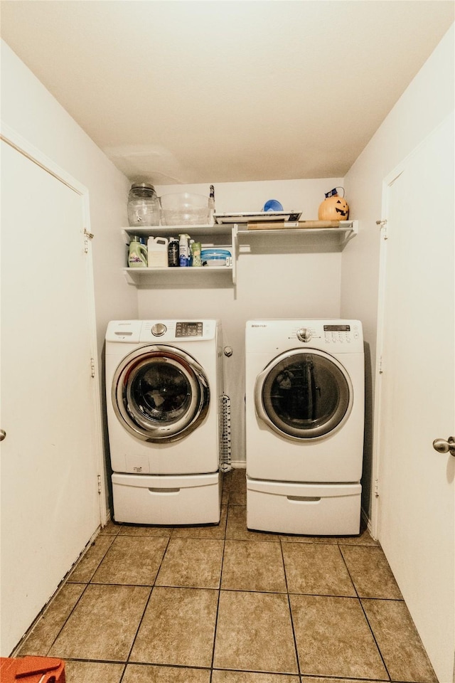 clothes washing area with washer and dryer and light tile patterned floors