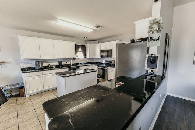 kitchen featuring white cabinetry, sink, decorative backsplash, light tile patterned floors, and electric stove