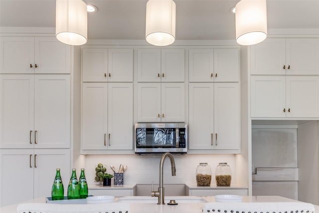 kitchen featuring hanging light fixtures, white cabinets, and decorative backsplash